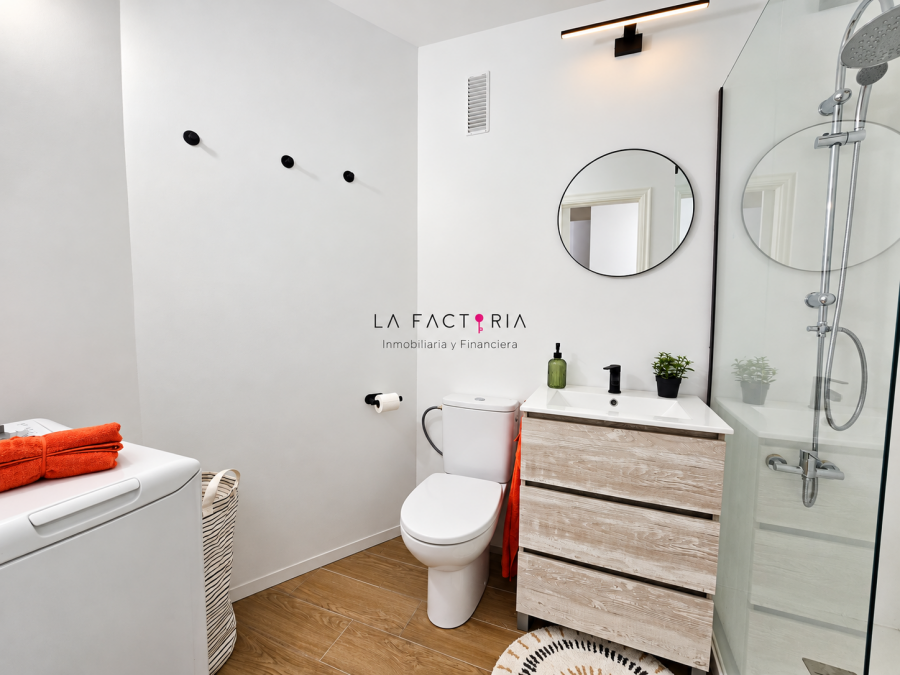 Baño moderno con detalles naranjas y madera.png
