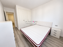 Dormitorio moderno con cama burdeos y armario blanco.png